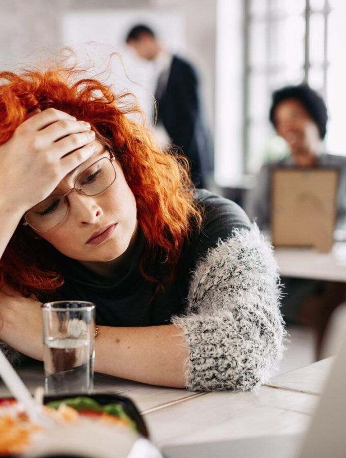 Redhead looking down at table, pensive